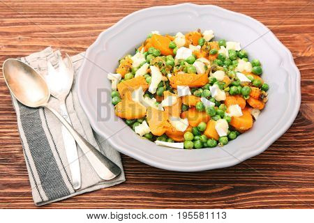 Warm salad with roasted pumpkin, peas and cheese brie. Low fat healthy eating concept.