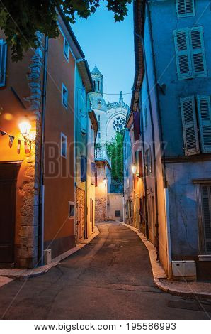 View of narrow alley and church in the early evening with lamp lit, in the lovely village of Rians. Located in Var department, Provence region, in southeastern France.