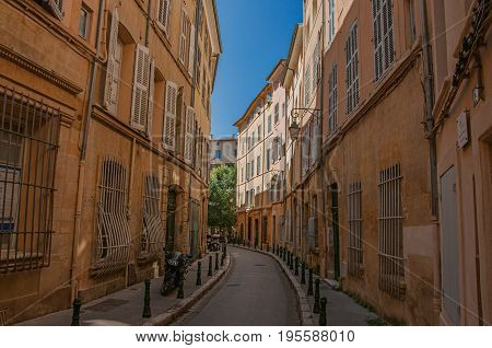 Aix-en-Provence, France - July 09, 2016. Narrow alley with buildings in the shadow in Aix-en-Provence, a pleasant and lively town in the countryside. Provence region, southeastern France