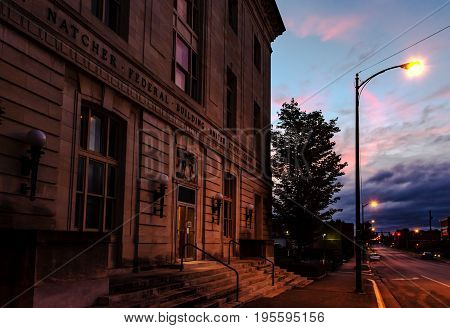 Bowling Green Kentucky USA - June 22 2017: William H. Natcher Federal Building and United States Courthouse at dusk lit by a streetlamp. It is a three-story Renaissance Revival white limestone building with a rusticated base.