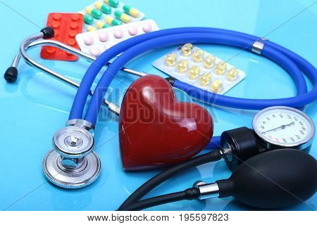 RX prescription, Red heart, asorted pils and a stethoscope on white background.