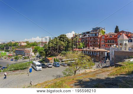 TBILISI GEORGIA - May 01 2017. Tourists walking near Tiflis Metekhi Hotel and park Rike. Panorama view on old town from Metekhi Church of the Dormition of the virgin.