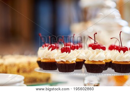 Freshly baked delicious cupcakes decorated with butter cream and cherries on top cherry fruit berry delicious tasty eating nutrition copyspace.