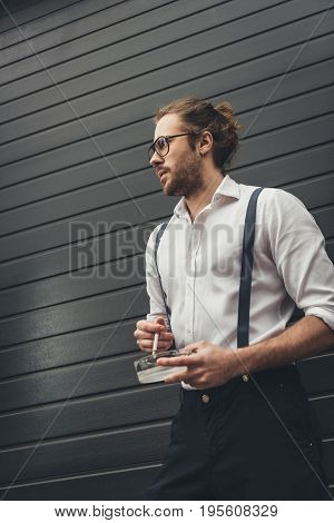 Handsome Stylish Young Man In Spectacles Holding Ashtray And Smoking Cigarette