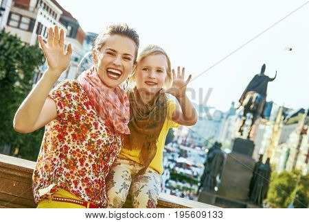 The spirit of old Europe in Prague. happy young mother and daughter tourists on Wenceslas Square in Prague Czech Republic handwaving