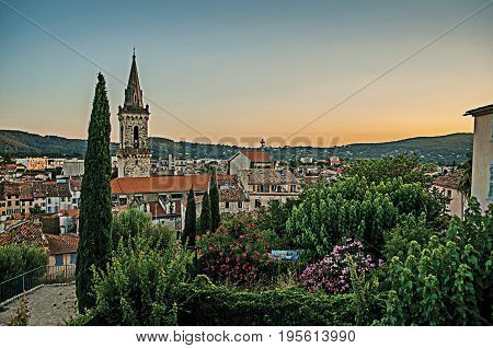 Draguignan, France. View from the hill of the clock tower of the graceful town of Draguignan at the sunset. In the Provence region, Var department, southeastern France. Retouched photo