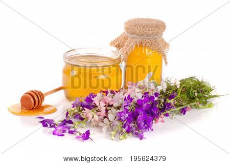 Jar of honey with wildflowers isolated on white background.