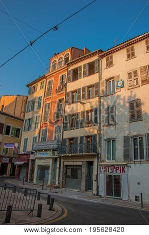 Draguignan, France - July 11, 2016. View of alley with townhouses and pedestrians in the city center of the lively and gracious town of Draguignan. Var department, Provence region, southeastern France