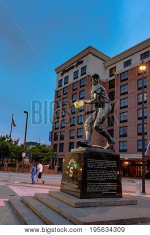 Baltimore Maryland USA - July 11 2017: Statue of Brooks Robinson in front of Camden Yards home of the Baltimore Orioles with tourists walking in the background.