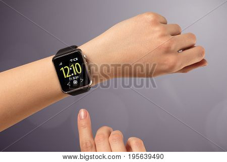 Naked female hand with smart wristwatch and digital clock on the screen 