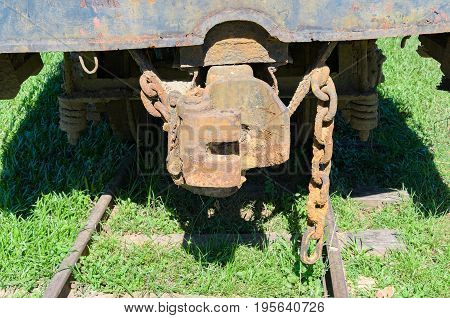 Rusted Train Hitch And Chains Over Rail Of A Abandoned Train.