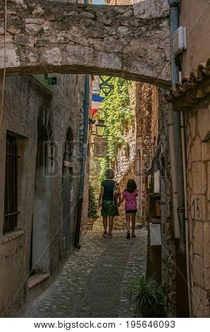 Saint-Paul-de-Vence, France - July 13, 2016. Mother and little girl in alley of stones in Saint-Paul-de-Vence, stunning medieval town completely preserved. In Provence region, southeastern France