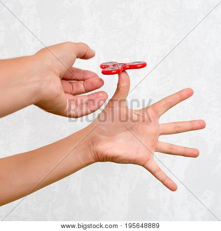 Fidget spinner. Red hand spinner, boys playing with fidgeting hand toy. Stress relief. Anti stress and relaxation adhd attention fad boy concept