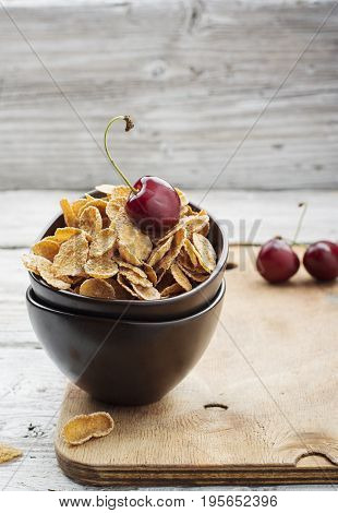 Healthy breakfast concept: whole-grain cereals with berries in ceramic bowls on a wooden light background. Selective focus