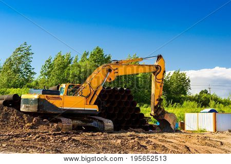 Crawler Excavator digging bucket on construction of high-speed ring road around Krasnoe Selo Saint Petersburg. Heavy machine equipment for excavation works at civil industrial construction. Russia