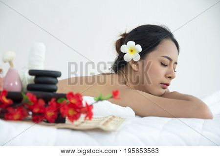 Thai Girl Lay Down On The Bed In Spa With Stone, Oil Equipment Beside.