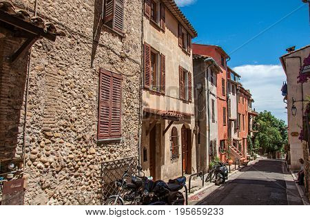 Haut-de-Cagnes, France - July 14, 2016. View of alleyway with houses on the slope and blue sky in Haut-de-Cagnes, a pleasant village on top of a hill. Alpes-Maritimes department, Provence region