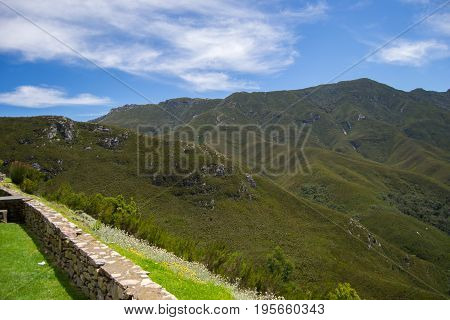 Mountains landscape with green vegetation blue sky with clouds and stone henge