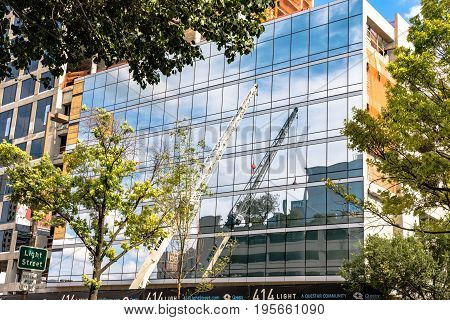 Baltimore Maryland USA - July 8 2017: Terex construction crane reflected on a building on Light Street in Baltimore Maryland.