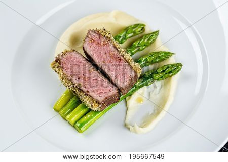 medium done grilled tuna steak with asparagus served on the asparagus and mashpotato