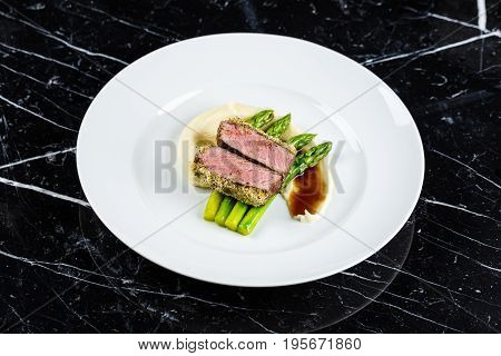 medium done grilled tuna steak with asparagus served on the asparagus and mashpotato