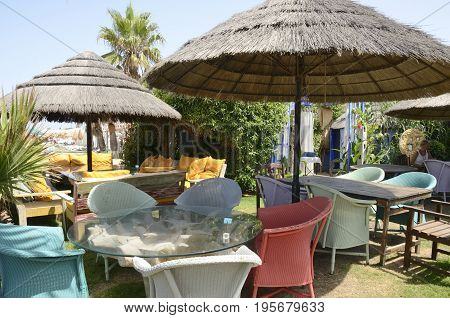 CHIPIONA, SPAIN - JULY 16, 2017: Colorful chairs in beach restaurant located in Chipiona a municipality of the province of Cadiz Andalusia Spain