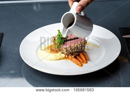 medium done grilled tuna steak in batter served with the baby carrot and mashpotato