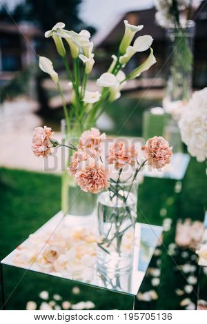 White And Peach Flovers In The Vases Stand On Mirror Cubes