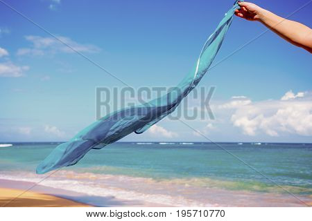 blue pareo shawls flowing in the wind on background of sea