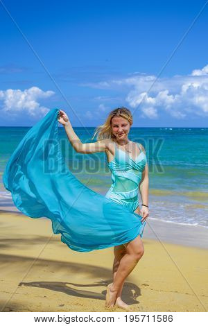 Young beautiful girl with blue pareo on tropical beach