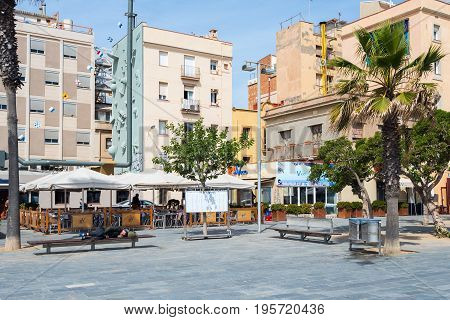 BARCELONA, SPAIN - MAY 2017: Street of Barcelona town with homeless man laying on a bench.
