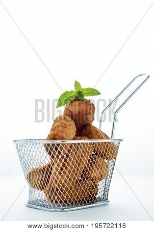 some homemade croquetas, spanish croquettes, served in a metal basket, on a white background, with a negative space on top