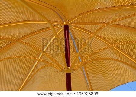Golden metal parasol umbrella for ultraviolet light protection and sunshade on hot summer days