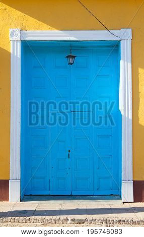 Typical colonial building with small door in the big gate Trinidad Cuba