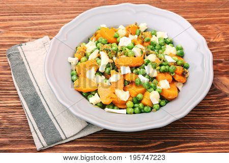 Warm salad with roasted pumpkin, peas and cheese brie. Low fat healthy eating concept.