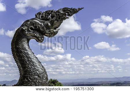 a Phayanak or Naga Statue on sky and cloud background, Thailand.