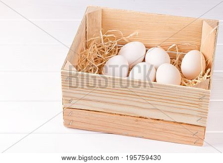 EA dozen white eggs in a wooden box