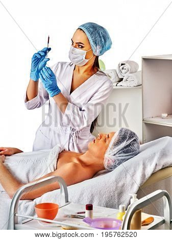 Filler injection for male forehead face. Plastic aesthetic facial surgery in beauty clinic. Folded towels in the background. Approach to cosmetology operation.