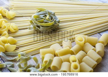 Piece of green pasta is on the yellow linguini