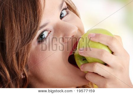 Teen pige spiser grean apple isoleret på hvid baggrund
