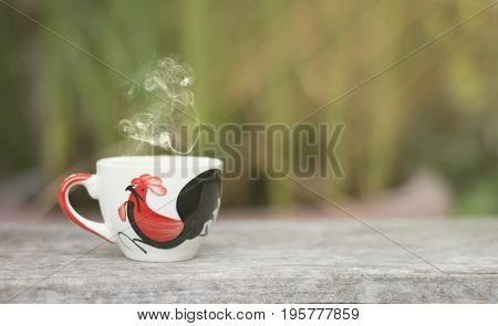 White cup morning coffee in garden and sunrise