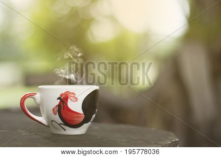 White cup morning coffee in garden and sunrise