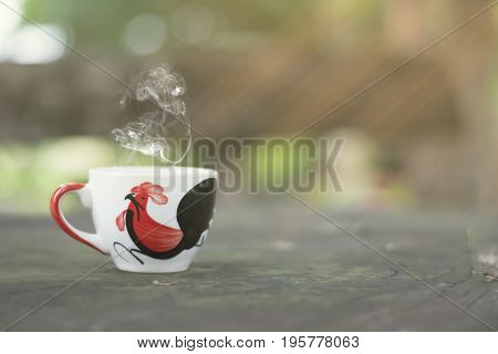 White cup morning coffee in garden and sunrise