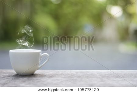 White cup morning coffee in garden and sunrise