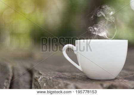 White cup morning coffee in garden and sunrise