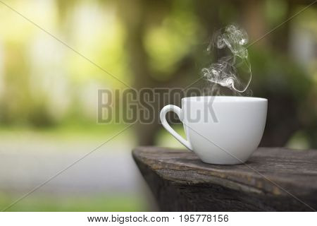 White cup morning coffee in garden and sunrise
