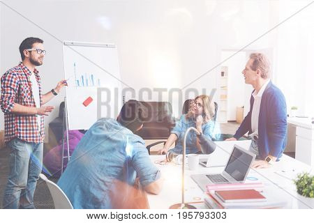 Show the tendency. Professional colleagues analyzing their business and talking about new strategies while working in the office