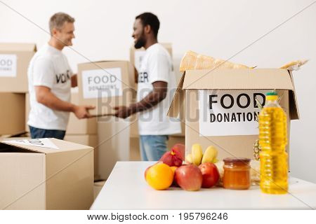 We can manage it. Handsome devoted admirable guys working in a warehouse where donated food being stored and helping moving it pro bono