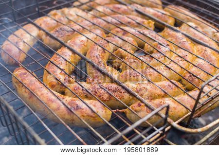 Grilling sausages on barbecue grill. Selective focus.