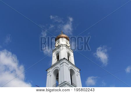 A dome of white orthodox cathedral tower with clock low angle view